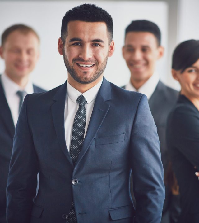 Leader of team Portrait of confident business partners looking at camera with smiling leader in front
